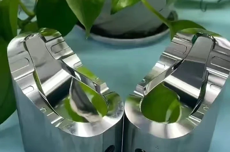 Polished deep-cavity mirror mold inserts showing high-gloss freeform surfaces at Yishun Optical